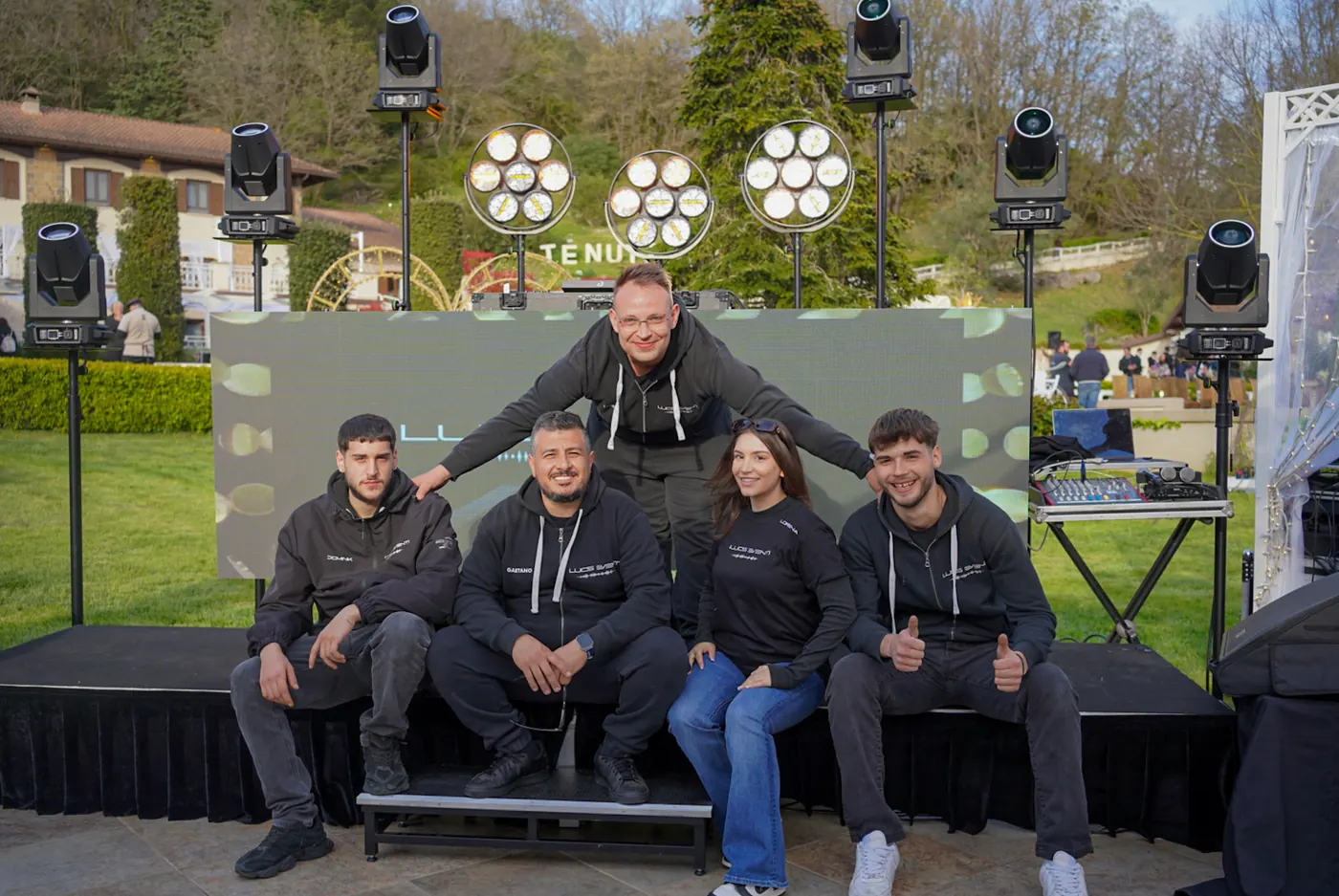 Lo staff di Lucs Eventi davanti al palco col ledwall, in felpa nera col logo