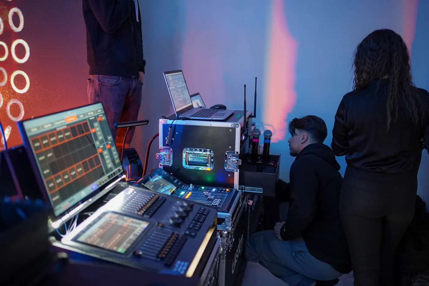 La regia col mixer, il rack dei radiomicrofoni e due tecnici al lavoro