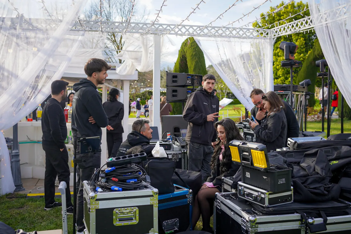 Allestimento in giardino: flight case, cavi e teste mobili sotto una pergola