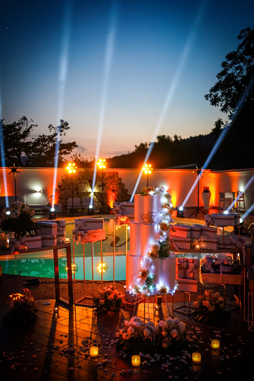 Fasci di luce al tramonto sopra la piscina, con la torta